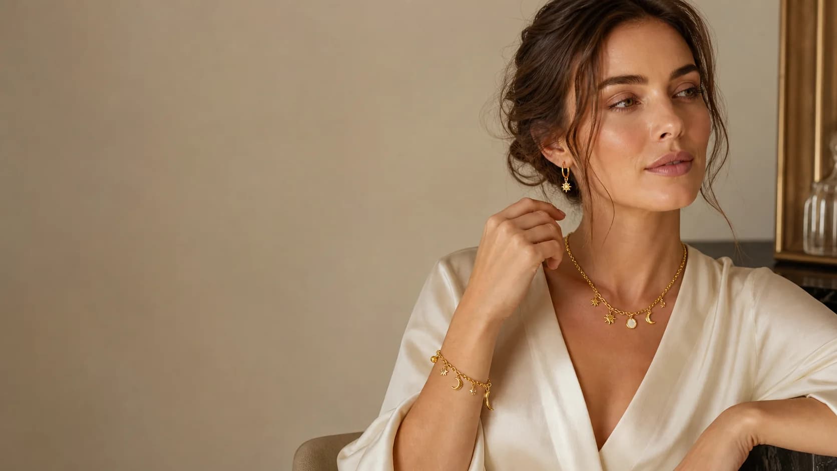 Model wearing PVD 14K gold stainless steel charm necklace, bracelet, and earrings